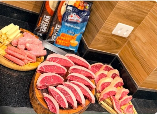 Churrasco preparado por ganhador com os cortes do kit: picanha fatiada e linguiças na tábua